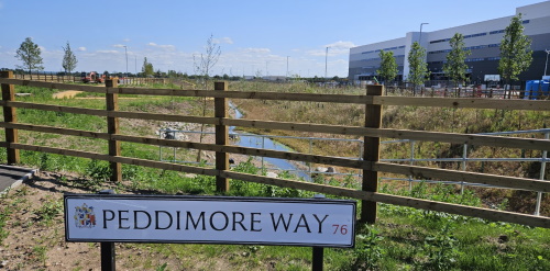 This image: a photograph of the new street sign for Peddimore Way. 
						 The map: the map shows the site layout.